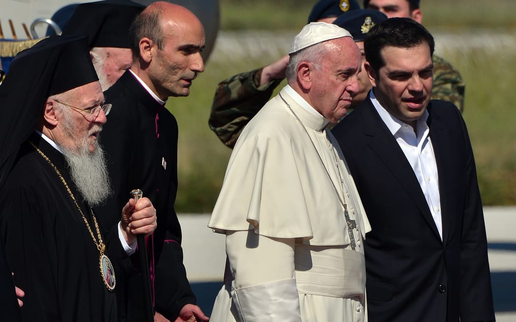 Greek Prime Minister Alexis Tsipras, right, and Archbishop of Constantinople and Ecumenical Patriarch Bartholomew I, left greet Pope Francis at the airport  on the Greek island of Lesbos on April 16, 2016.