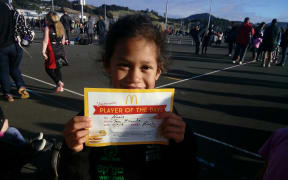 Alexis holding up a player of the day certificate.