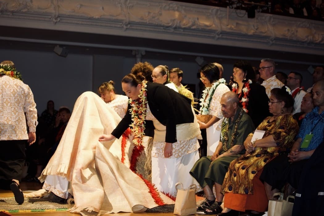 A mat is put over Prime Minister Jacinda Ardern as part of the Ifoga protocol.