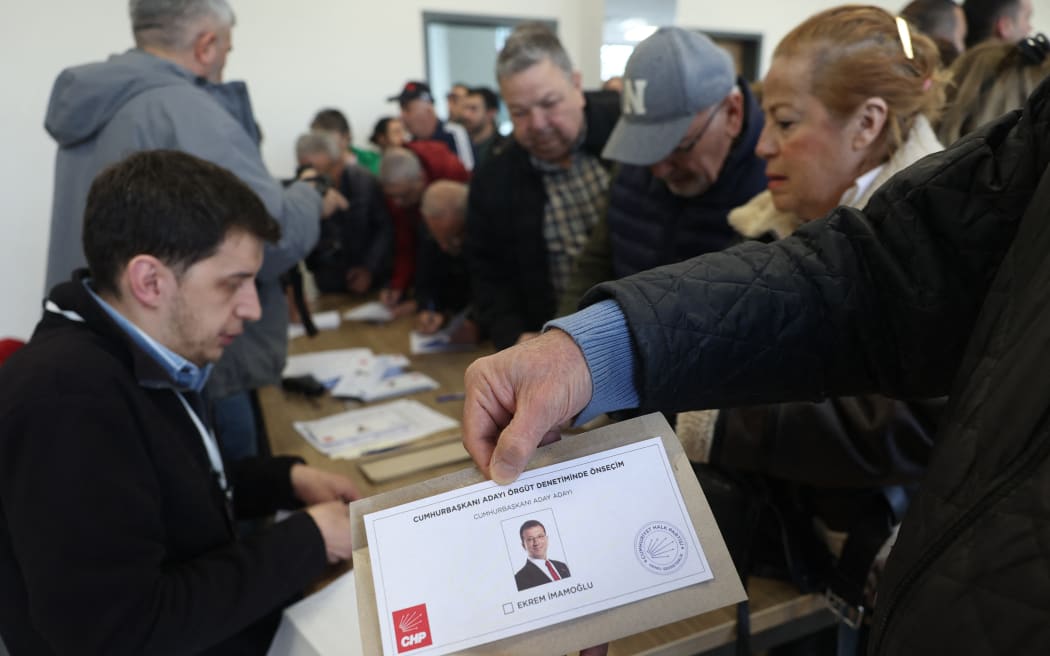 A man shows a ballot paper of the only candidate of the opposition Republican People's Party (CHP) Ekrem Imamoglu during the presidential primaries at a polling station in Ankara on March 23, 2025. The popular opposition Istanbul Mayor Ekrem Imamoglu, who is the biggest political rival of President Recep Tayyip Erdogan, was arrested on March 19, just days before he was to be named the main opposition CHP's candidate for the 2028 presidential race. The opposition Republican People's Party (CHP) has opened the vote to anyone, not just party members, in the hope of a massive show of support for the beleaguered mayor.