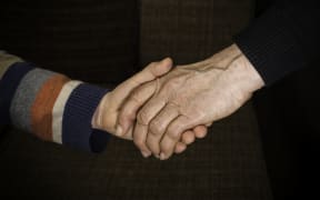 An adult holding a child's hand