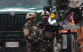 Afghan security personnel investigate the site of a suicide attack that targeted a foreign forces convoy near the US embassy in Kabul on May 3, 2017.