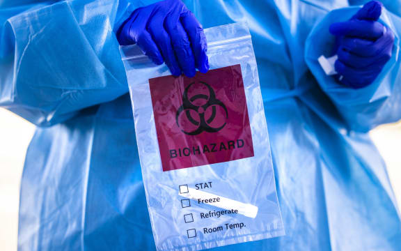 Covid-19 tester holds a bag after administering a test at Echo Park Stadium on December 30, 2020 in Parker, Colorado.