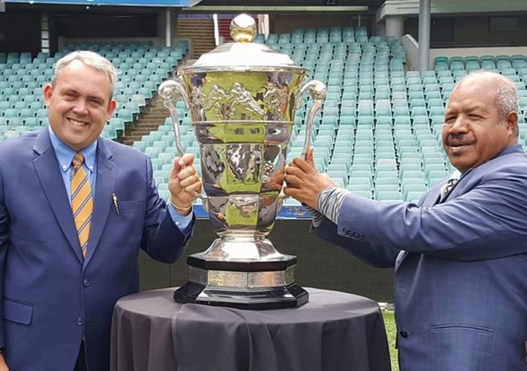 Papua New Guinea Minister for Sports, Honourable Justin Tkatchenko, and National Capital District Governor, Honourable Powes Parkop, pose with the Rugby League World Cup.