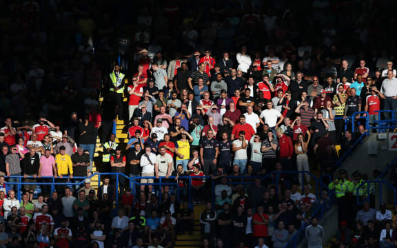 Arsenal fans in sunshine in the away stand at Arsenal.