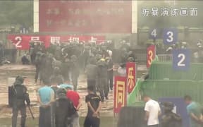 This screengrab taken from undated handout three-minute promotional video received on August 1, 2019 from China's People's Liberation Army (PLA) Hong Kong Garrison shows "protesters" being detained by PLA soldiers during an "anti-riot" drill in Hong Kong.