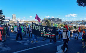 Protesters carry a "people not profit" banner at an Auckland climate protest.