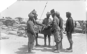 THE GALLIPOLI CAMPAIGN, APRIL 1915-JANUARY 1916: Troops of the 14th Sikhs of the 29th Indian Infantry Brigade examining a piece of shell from 'Asiatic Annie' that fell in their camp.