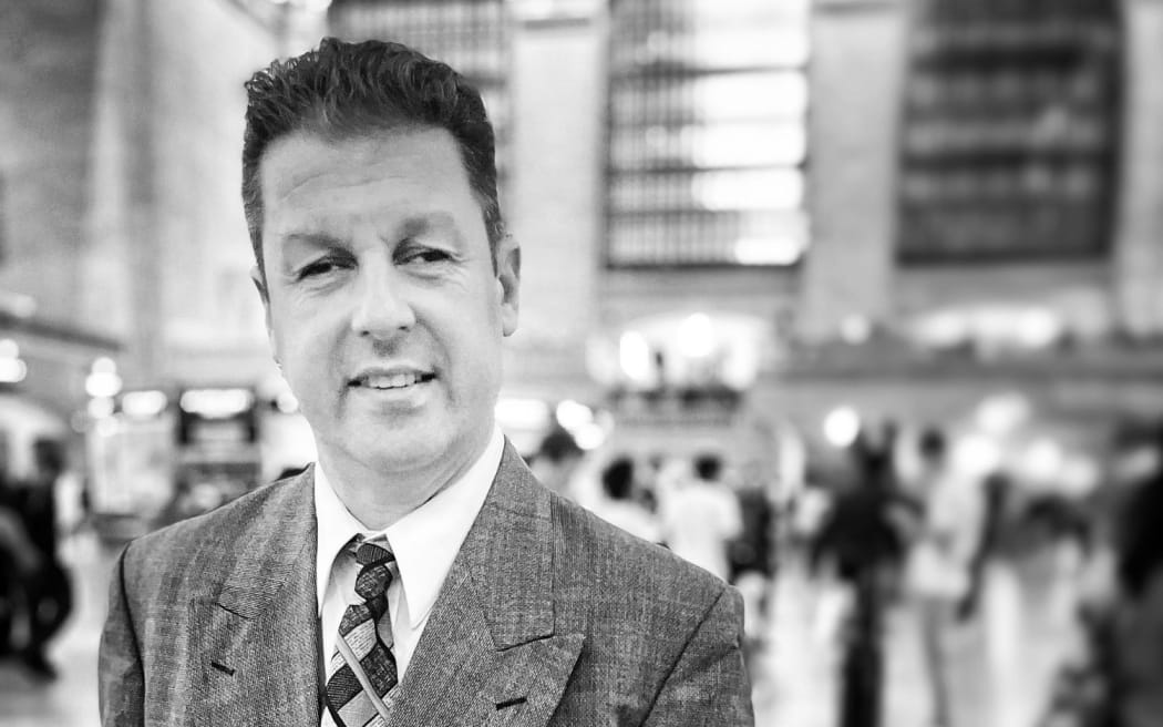 New Zealand drummer Mark Lockett wearing a suit and standing in New York's Central Station