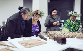 Members of the Cook Islands community look at Auckland Museum's extensive collection, which is being brought out as part of a new project.