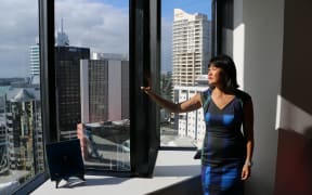 Woman looking out a high rise window
