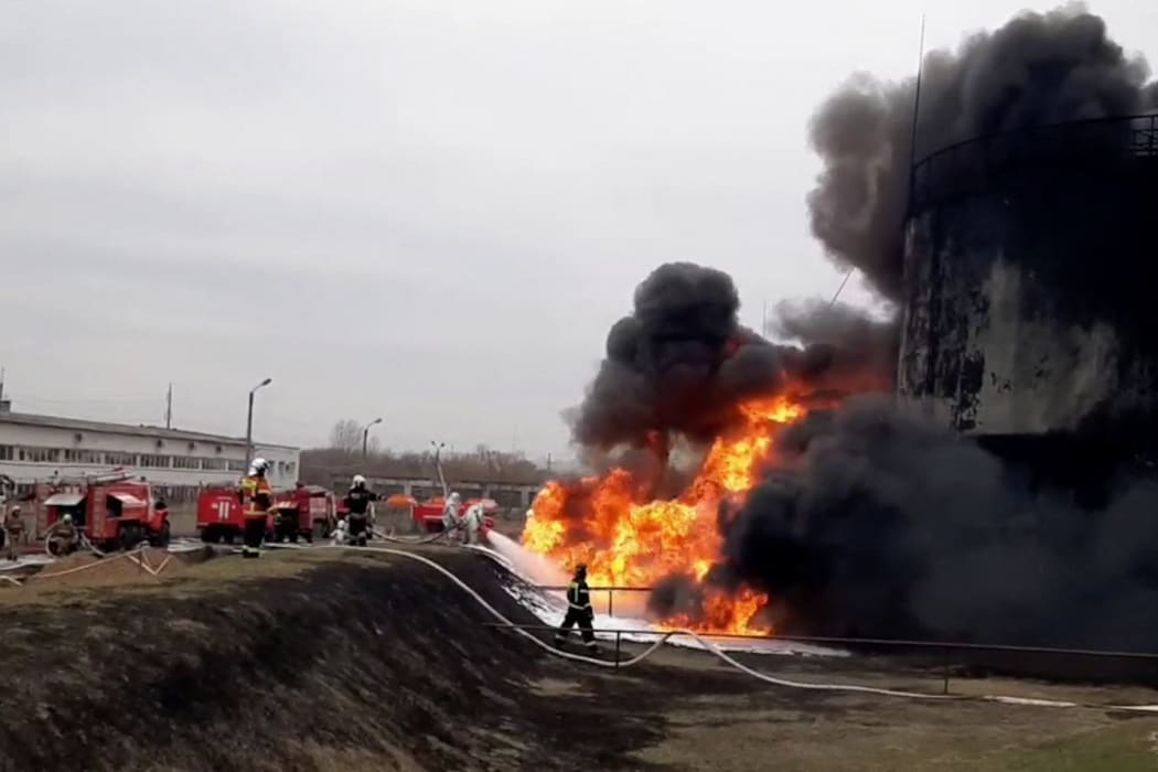 This video grab taken from a handout footage released by the Russian Emergencies Ministry on 1 April, 2022 shows firemen working to extinguish a fire at a Rosneft fuel depot in the town of Belgorod, some 40km from Russia's border with Ukraine.