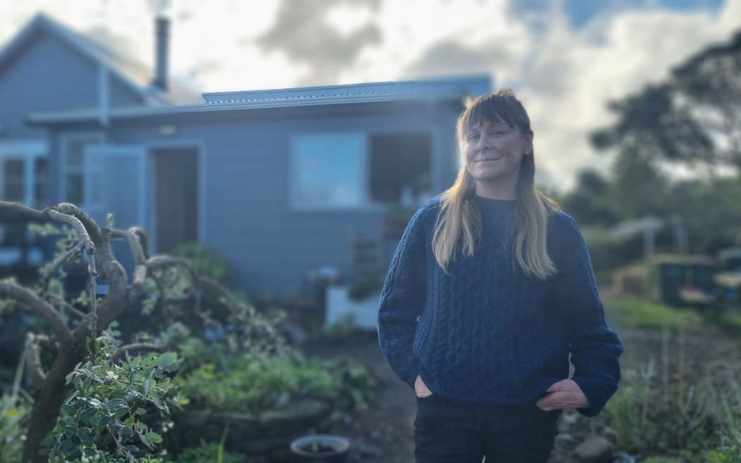 Rebecca James outside her colonial-era cottage in Ōpunake.