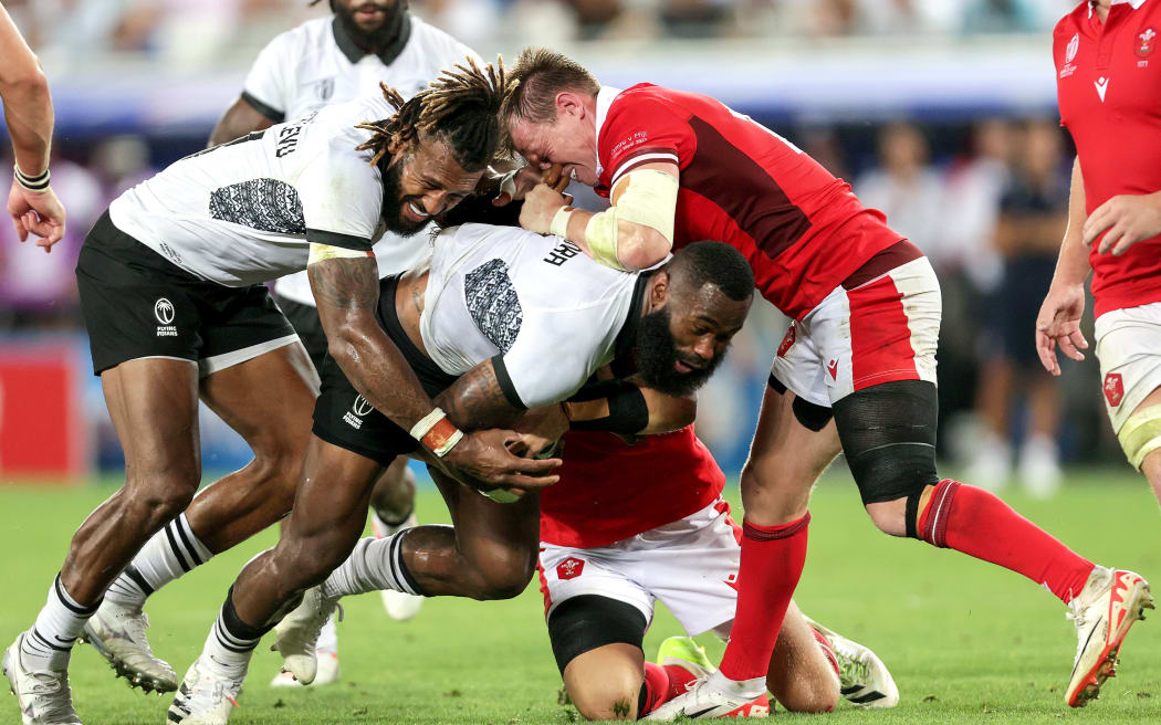 Fiji's Semi Radradra and Waisea Nayacalevu with Nick Tompkins of Wales during their 2023 Rugby World Cup game.