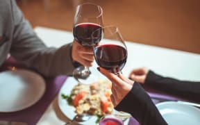 Couple sharing a meal and a glass of wine.