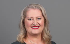 Kate Gudsell smiling with grey background