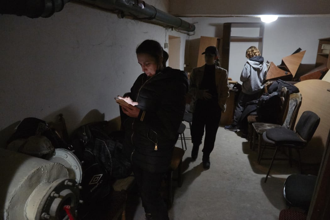 Local residents follow the news on their mobile devices in a bomb shelter on February 24, 2022 in Kyiv, Ukraine.