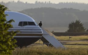 AMESBURY, WILTSHIRE - JUNE 14: A man stands on the steps of the grounded Rwanda deportation flight EC-LZO Boeing 767 at Boscombe Down Air Base, on June 14, 2022 in Boscombe Down near Amesbury, Wiltshire, England. The flight taking asylum seekers from the UK to Rwanda has been grounded at the last minute after intervention of the European Court of Human Rights. (Photo by Dan Kitwood/Getty Images)