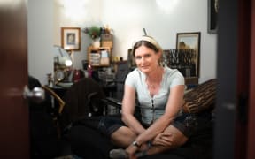 Kristine, pictured sitting on the bed in her room.