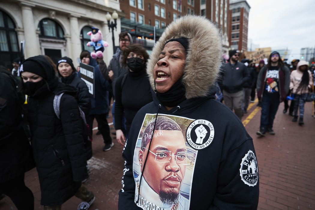 A woman wears a sweater with an image of Patrick Lyoya as protesters march for Lyoya, a Black man who was fatally shot by a police officer, in downtown Grand Rapids, Michigan, April 16, 2022.