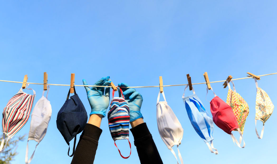 Drying mask hanging under the sun after use for disinfecting. Hygienic mask hanging on the rack outdoor after being washed for cleanness and hygiene during Covid-19 virus outbreak