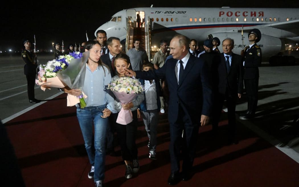 In this pool photograph distributed by Russian state agency Sputnik, Russia's President Vladimir Putin welcomes Russian citizens released in a major prisoner swap with the West, at Moscow's Vnukovo airport on August 1, 2024. (Photo by Mikhail VOSKRESENSKIY / POOL / AFP)