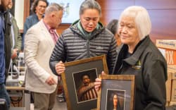 Whānau carry pictures of their ancestors into the High Court.