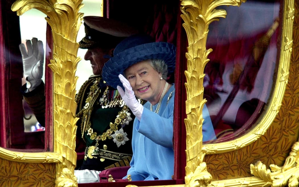 Britain's Queen Elizabeth II waves to the crowd as she rides 04 June 2002 in the Gold State coach from Buckingham Palace to St Paul's Cathedral for a service of Thanksgiving to celebrate to her Golden Jubilee. The coach was built for King George III in 1762, and has only been used by the Queen twice before -- for her Coronation, and her Silver Jubilee.