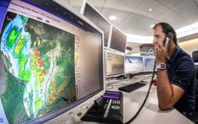 09 August 2018, Germany, Frankfurt am Main: Thomas Fenske, shift manager at Lufthansa's operational control center, is planning to reschedule or even cancel flights in view of an approaching storm front (weather radar on a screen on the left). Frankfurt Airport temporarily suspended flight operations in the afternoon due to the storm front. Photo: Frank Rumpenhorst/dpa (Photo by FRANK RUMPENHORST / DPA / dpa Picture-Alliance via AFP)