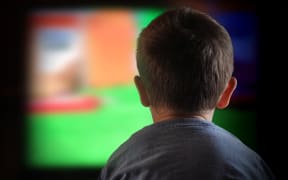 A close-up of a child watching television