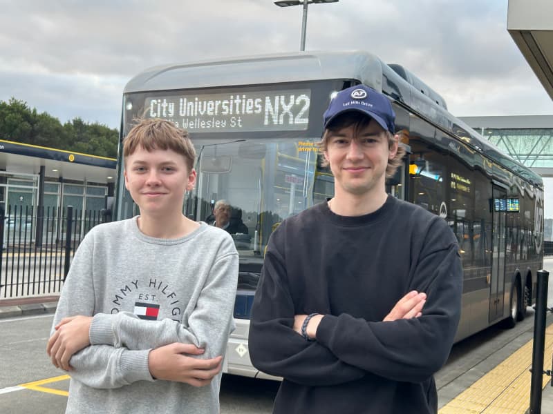 A photo of George and Robert Richards standing in front of the NX2 bus.