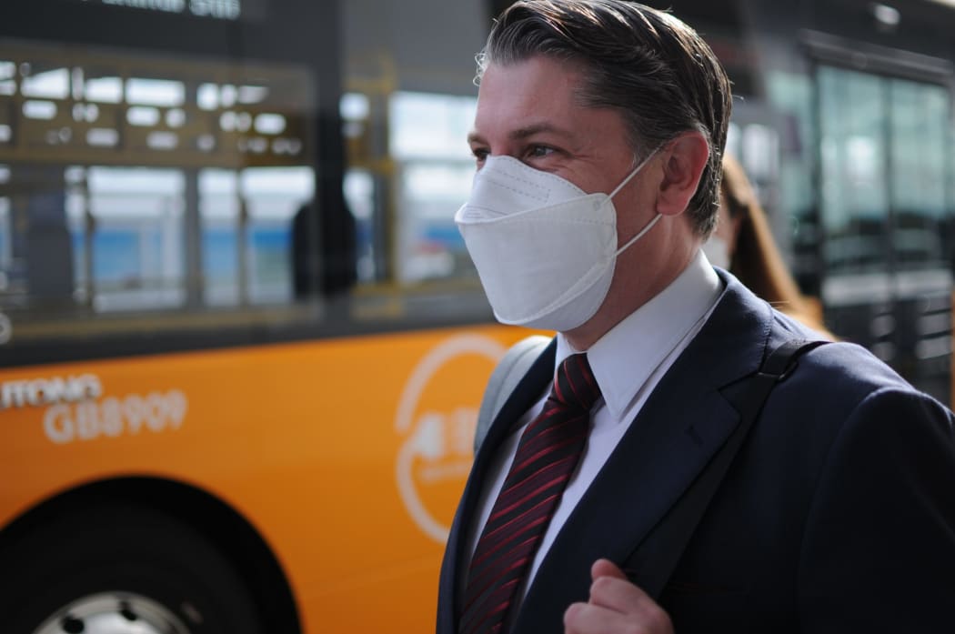 Minister of Transport Michael Wood waiting to catch an AirportLink bus to Puhinui Station Interchange on Friday.