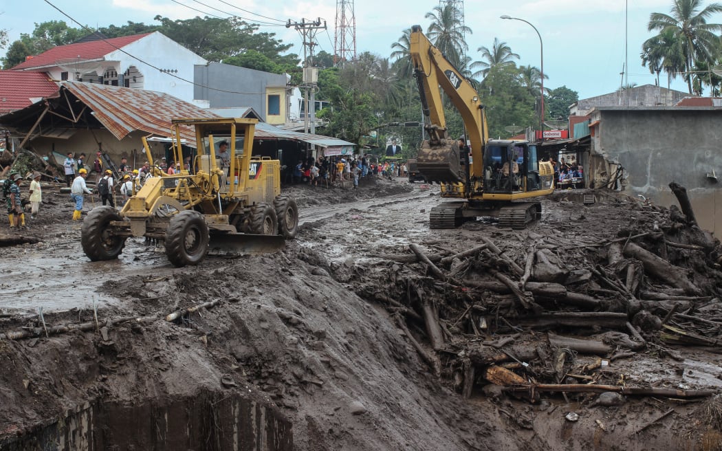 Heavy machinery clear mud and debris from the scene following deadly flash floods and cold lava flow in Tanah Datar, West Sumatra, on May 13, 2024. The death toll from flash floods and cold lava flow from a volcano in western Indonesia over the weekend has risen to 44 with 15 more missing, officials said on May 13. (Photo by Ade Yuandha / AFP)
