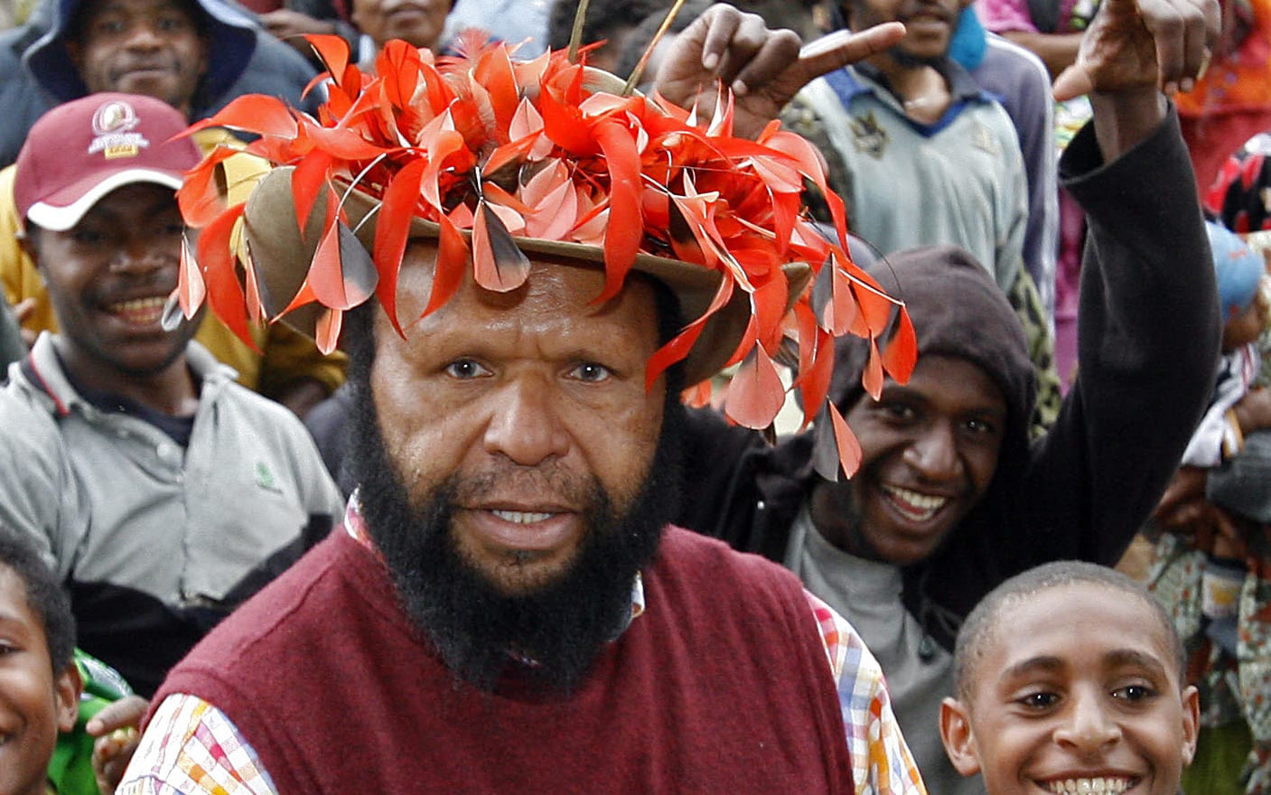 Paias Wingti (C), Governor of the Western Highlands province and former two-time PNG prime minister, wears his trademark bird of paradise hat as he returns to Ketiga village to vote during Papua New Guinea's general election, 06 July 2007.