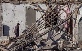 A resident walks among debris of a destroyed building following a missile attack at an undisclosed location in Odesa region on 17 November, 2024. Russia pounded Ukraine with "one of the largest" aerial attacks it has suffered in an assault that targeted the country's energy infrastructure, Kyiv's Foreign Minister Andriy Sybiga said on November 17, 2024.