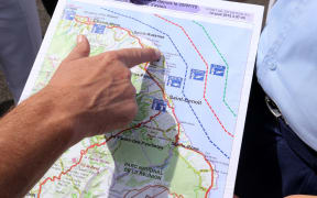 French maritime gendarmes look at a map indicating measures being undertaken in the search for wreckage from the missing MH370 plane at the marina of Saint-Marie on the French island of La Reunion on August 14, 2015.