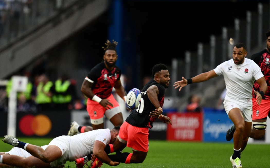 Fiji's fly-half Vilimoni Botitu (C) is tackled by England's loosehead prop Ellis Genge (L) next to England's outside centre Joe Marchant during the France 2023 Rugby World Cup quarter-final match between England and Fiji at the Velodrome Stadium in Marseille, southeastern France, on October 15, 2023.
