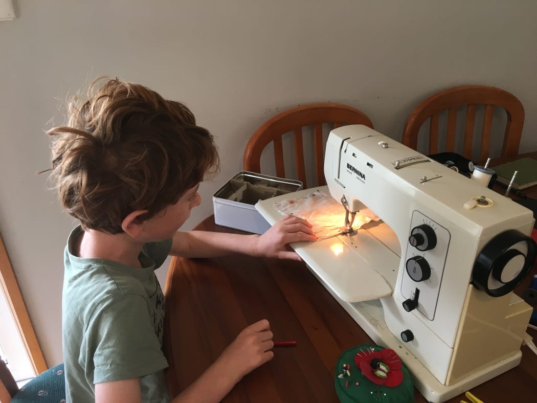 Sophie's son works the sewing machine.