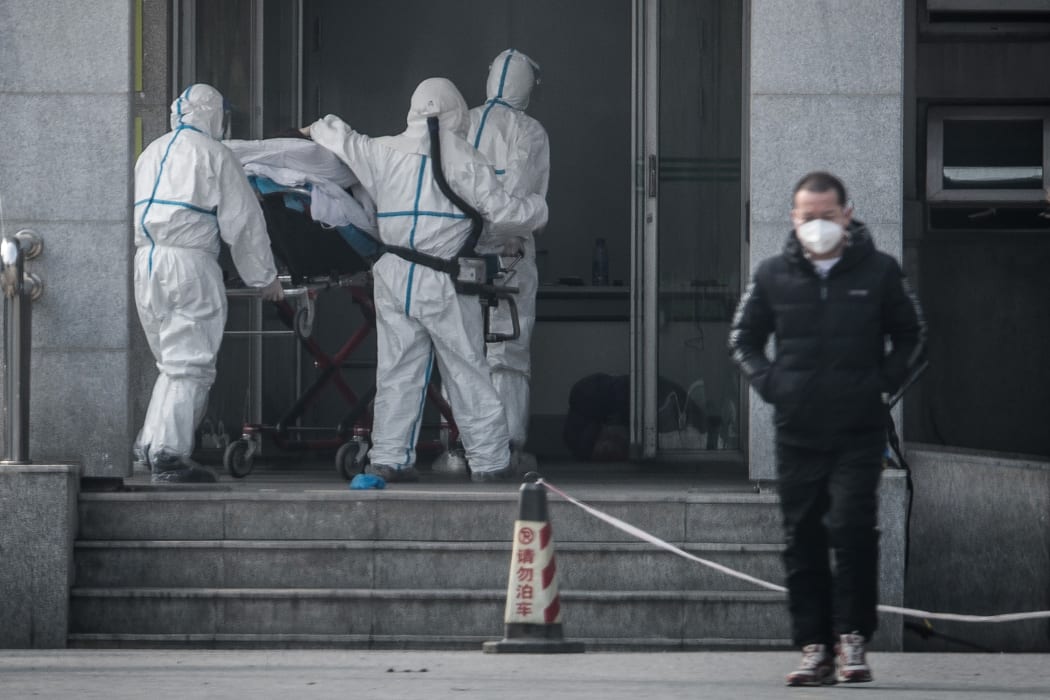 Medical staff carry a patient into the Jinyintan hospital, Wuhan, on 18 January. Chinese officials have confirmed more than 200 cases, mostly in Wuhan.
