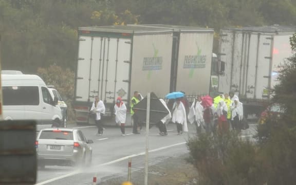 Survivors from the bus crash are led away from the scene.