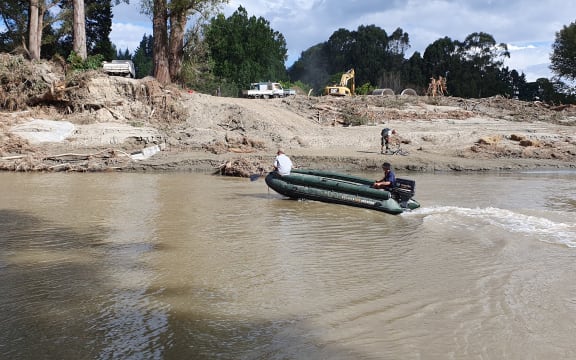 The army green pontoon boat Rissington locals use to ferry essential supplies across the river.