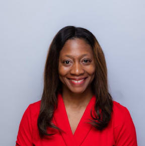 A portrait photo of Dr Fatima Cody Stanford associate professor of medicine and pediatrics at Harvard Medical School. She is smiling and wearing a red top.