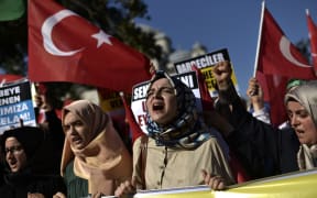 Pro-Erdogan protesters wave Turkish flags and shout slogans as they demonstrate in Istanbul in support the government on July 16, 2016, following a failed coup attempt.