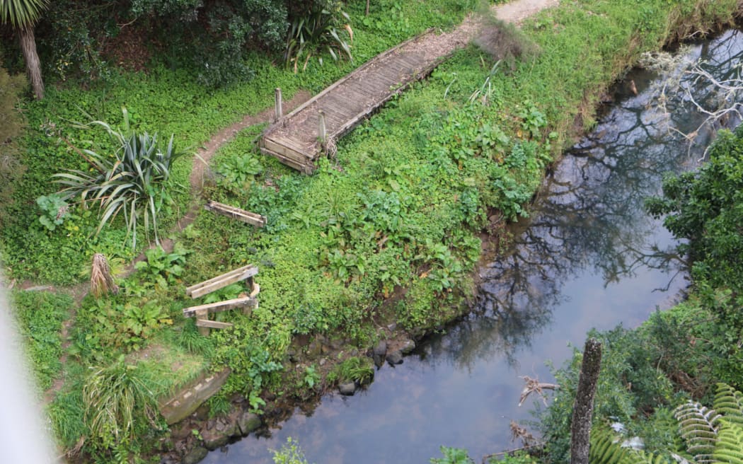 A section of path washed away, foundations of where the path previously still stood are visible, along with greenery.