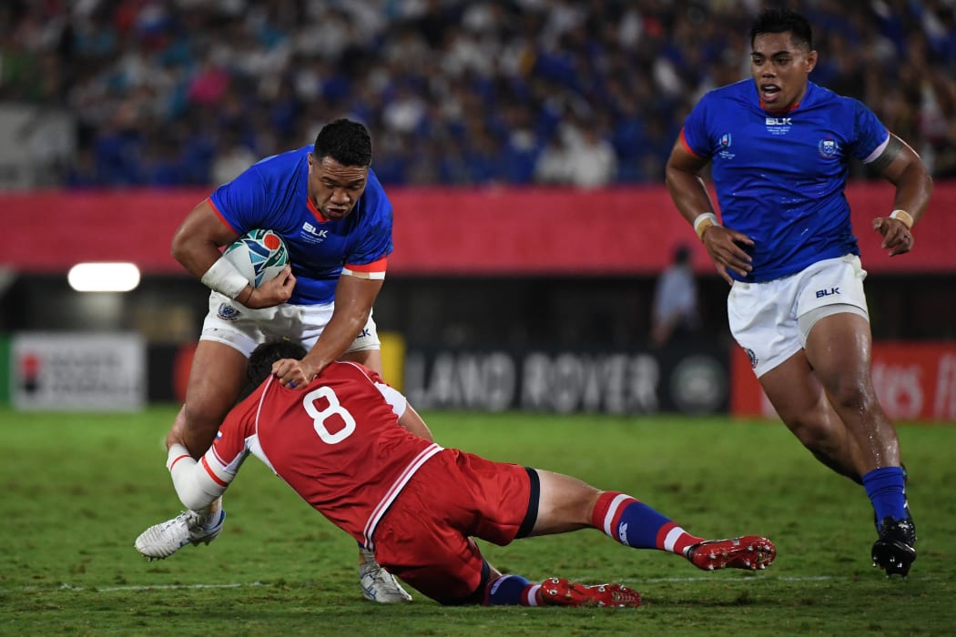 Samoan hooker Motu Matu'u is tackled by Russia's number eight Nikita Vavilin.