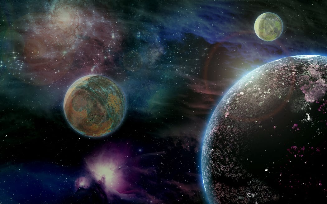 Computer illustration of an extrasolar planet with three moons and gaseous nebula.