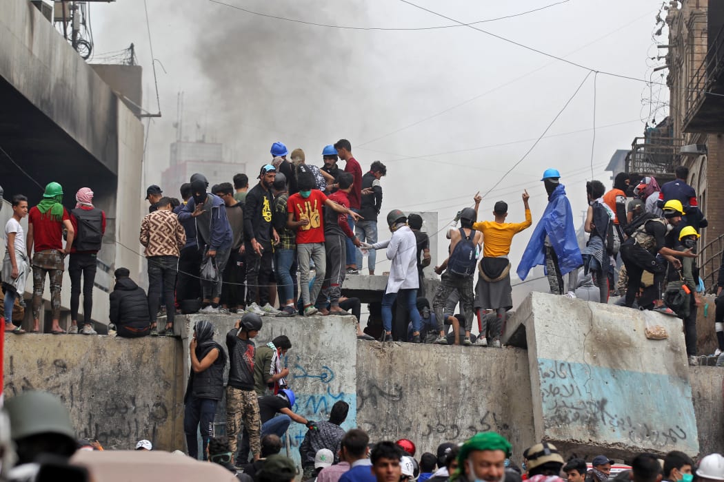 Iraqi protesters clash with Iraqi security forces in al-Rasheed Street during ongoing anti-government demonstrations against corruption.