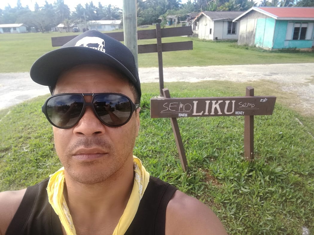 Actor Shimpal Lelisi poses before the sign identifying his village of Liku in Niue.