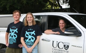 Chloe Fraser (seated in car), Tim Greene, and Isabella Fanselow. 
Members of the Christchurch Student Volunteer Army who are organising rides for members of the Muslim student community.