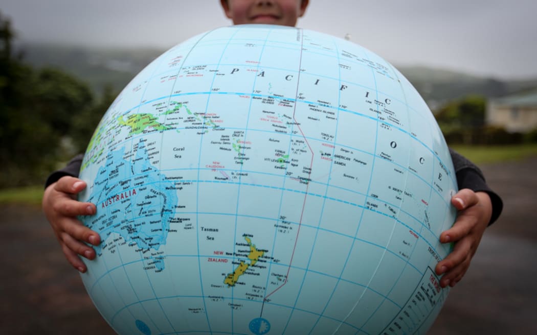 A kid from Hampton Hill Primary holds up the world.